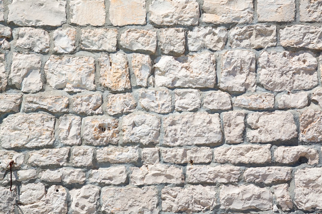 Professional mason restoring and repairing stone facade with skilled technique